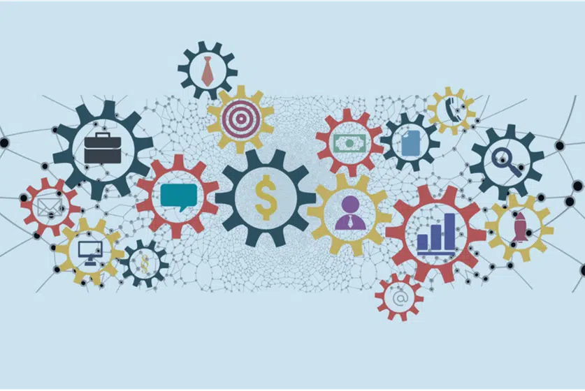 Illustration of interconnected gears with various icons, including a dollar sign at the center, a target, a briefcase, a computer monitor, pie charts, and currency symbols. The gears represent leadership and strategy as they are connected by a network of lines and nodes on a light blue background. - Tapestry AG Illustration of interconnected gears with various icons, including a dollar sign at the center, a target, a briefcase, a computer monitor, pie charts, and currency symbols. The gears represent leadership and strategy as they are connected by a network of lines and nodes on a light blue background.